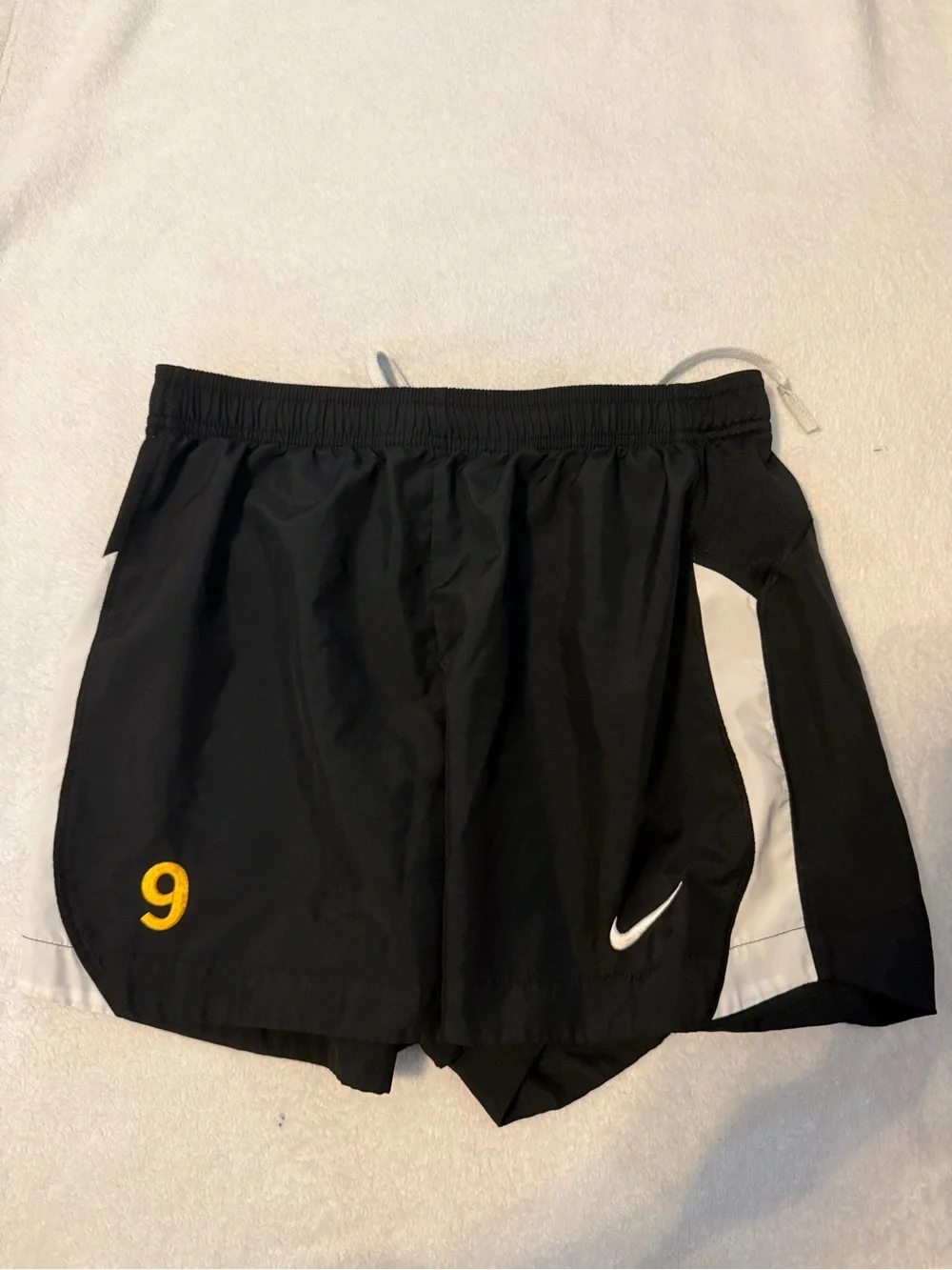 Nike Black Athletic Running Shorts with White Accents and Yellow Number